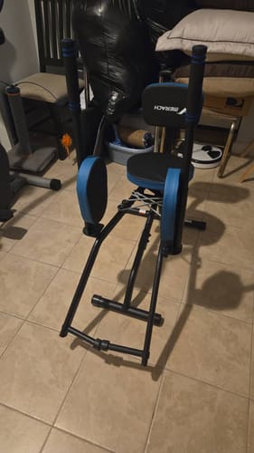 Customer's black and blue seated hip abductor machine assembled on a tiled floor.
