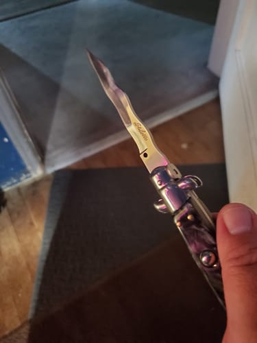 Customer's Kriss Blade Italian Stiletto with a wavy blade and dark handle held in a hand