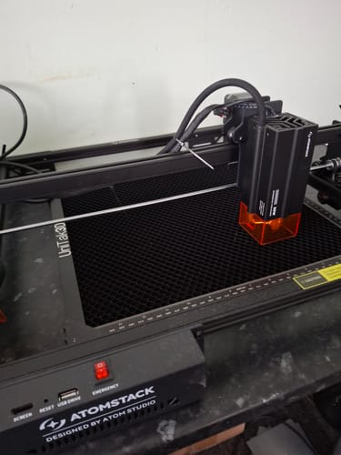 Customer's AtomStack A20 Pro V2 laser engraver setup with a honeycomb bed and orange protective shield.
