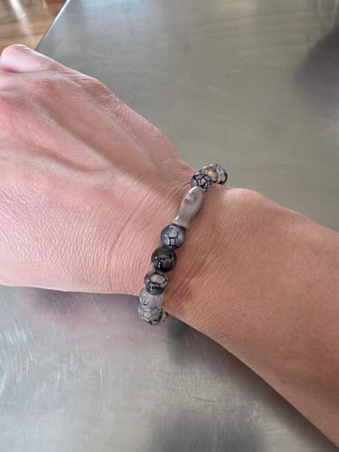 Customer's gray and black beaded Voyage Bracelet on a person's wrist.