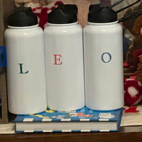 Customer's three white Sports Buddy water bottles personalized with individual letters spelling out L E O.