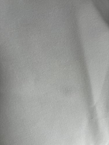 Customer's Special Offer Plain Cotton Canvas Fabric with a hand behind the material to show opacity.