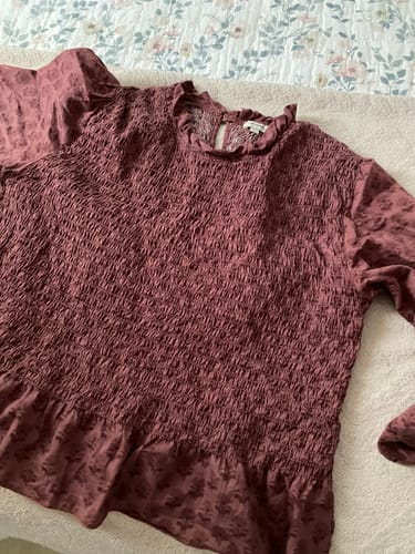 Customer's Blusa Panal Gardenia en color vino con textura de panal sobre una colcha