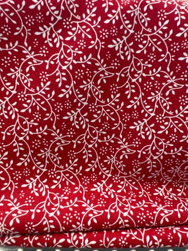 Customer's Mini Garden craft cotton fabric, showing a white delicate floral pattern on a vibrant red background.