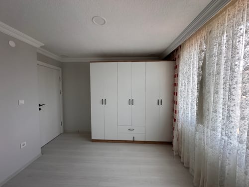 Müşterinin Rani BA111 beyaz gardırop elbise dolabı, yatak odasında kurulu bir şekilde duruyor.