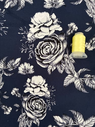 Customer's navy Large Roses cotton poplin fabric with a yellow cotton reel for size context.