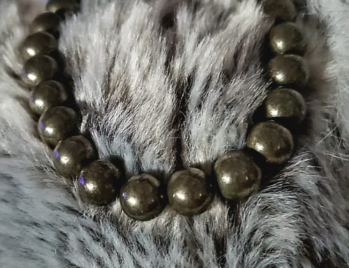 Customer's VIP Crystal Club pyrite beaded bracelet on a soft, grey textured surface