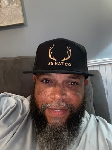 Customer's Hat of the Month Crew cap with gold deer antlers on a black hat, worn by the reviewer.