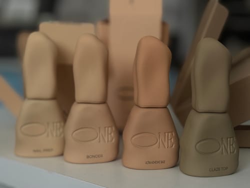 Customer's Bonder product bottle displayed alongside other beige beauty products on a white surface.