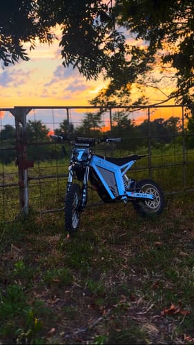 Customer's light blue Tuttio Soleil 01 bike parked on grass during a sunset