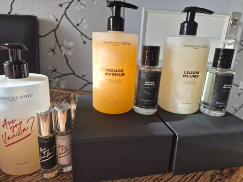 Customer's Lilium Blume perfume and body wash collection displayed alongside other skincare products on a wooden table.