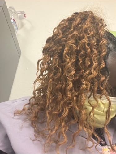 Reviewer's Light Brown Deep Wave Human Crochet Hair extensions worn in a high ponytail.