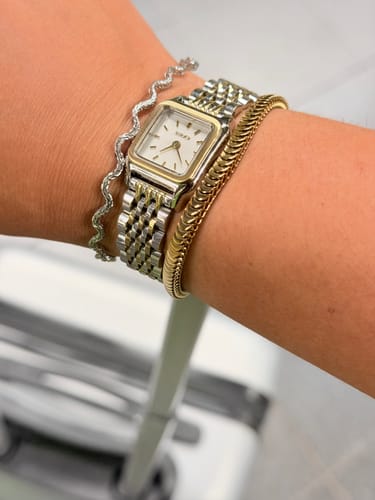 Customer's Macy Petite Gold Silver watch on a wrist, worn alongside two delicate bracelets.