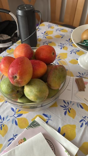 Customer's Baby-Mango Mix in a glass bowl on a table with a lemon-patterned tablecloth.