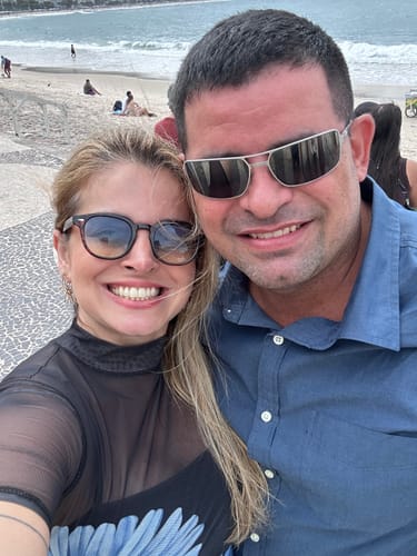 Customer's Óculos de Sol Jurerê, um modelo casual, sendo usado por uma pessoa em um dia ensolarado na praia.