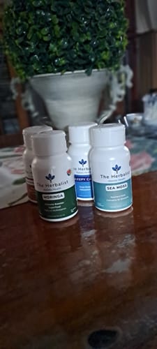 Customer's Reset Bundle, featuring three labeled white bottles of Moringa, Sleepy Cap, and Sea Moss on a wood table.