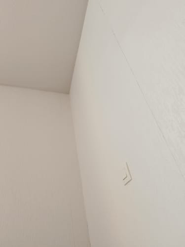 Customer's Meli lens packaging, blurry corner view of room