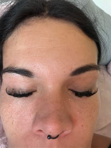 Customer's Augen mit geschlossenen Lidern, an denen SEALER Wimpern appliziert sind.