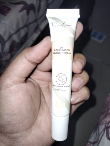 Customer's hand holding a tube of Advanced Lip Pigmentation Cream, showing the clear product label and branding.