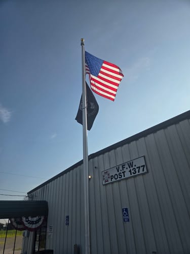 Reviewer's tall aluminum flagpole with two flags, installed outside V.F.W. Post 1377.