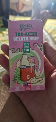 Reviewer's hand holding a pink and green Gelato Drip THC-A vape box with a product illustration.
