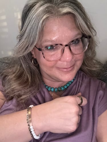 Customer wearing a white beaded Inspire Me bracelet with a rose gold metal bar on their wrist.