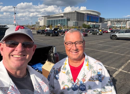 Customer wearing a patterned Record Adapter T-Shirt at a concert venue parking lot.