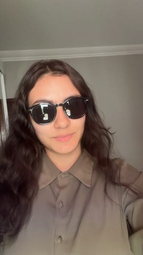 Customer's Óculos de Sol Jurerê com lentes escuras sendo usado por pessoa.
