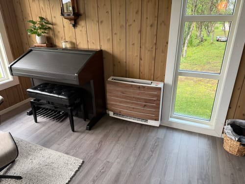 Customer's Artisan Oak kontaktplast brukt for å fornye fronten på en varmepumpe i en stue med trevegger.