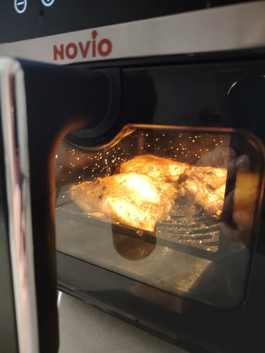 Customer's Novio StonePro air fryer with a clear window showing chicken cooking inside.