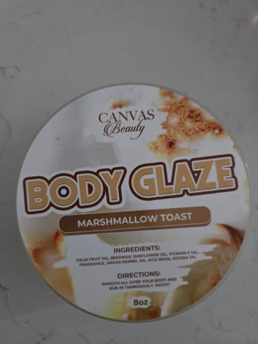 Customer's round container of Canvas Beauty Marshmallow Toast Body Glaze on a marble surface.