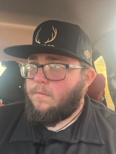 Customer's Hat of the Month Crew cap, featuring black fabric and a gold antler design, worn by a reviewer.