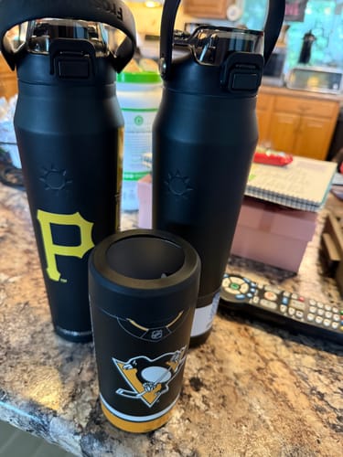 Customer's two black Bottle Buddy 32oz bottles and one smaller black drink sleeve on a countertop.