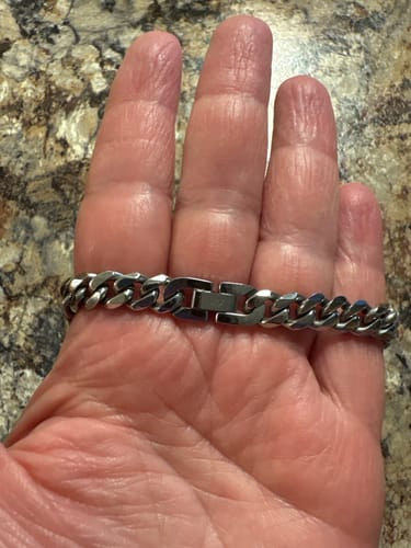 Customer's 8mm Cuban Link Chain resting on an open hand, showing the sturdy, shiny silver-toned metal clasp.
