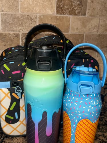 Customer's colorful Bottle Buddy replacement lid bottles sitting in front of a printed lunch bag.