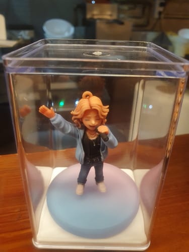 Customer's Personalized Mini-Me Keychain Chibi figure in a clear display case, showing a person with wavy hair