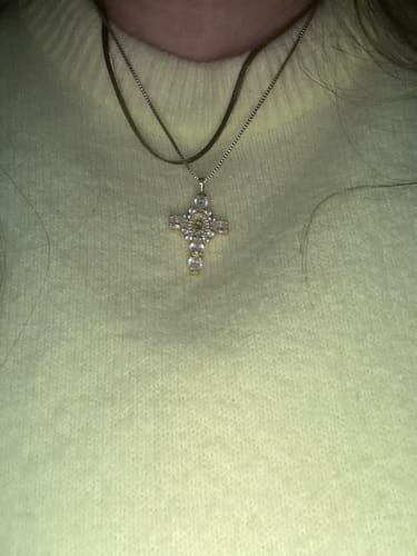 Customer's layered gold Valerie Virgin Mary Cross Pendants worn against a yellow sweater.