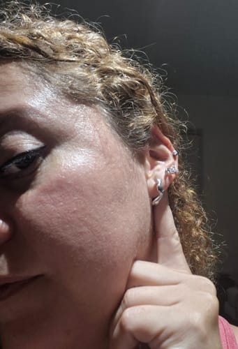 Customer's Aretes Brie Plata earrings, showing the silver design worn on their ear.