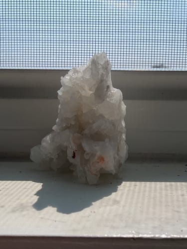 Customer's VIP Crystal Club monthly crystal, a translucent, jagged stone sitting on a window sill.
