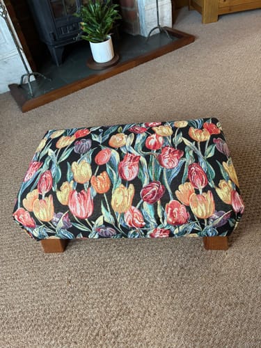 Customer's footstool covered in vibrant Tulip Garden Tapestry Fabric with a colourful floral pattern.