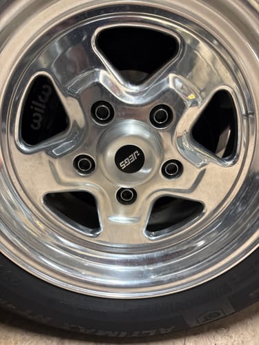 Customer's wheel spacer installed behind a polished metal wheel with a black center cap.