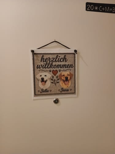 Customer's Diamond Painting eigenes Bild personalisiert mit Text und Hundeporträts, hängend an einer Tür.