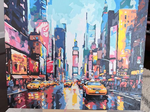 Customer's completed Taxi Streets paint-by-numbers canvas showing a vibrant city street scene with yellow taxis.