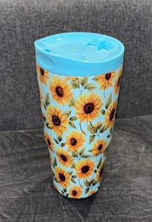 Customer's Sunflower Skies To-Go Buddy tumbler with a blue lid and sunflower pattern on a gray background