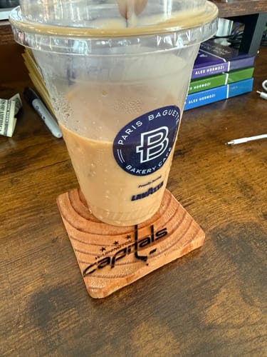 Customer's AtomStack Swift laser engraved wooden coaster featuring the Washington Capitals logo under a drink cup.