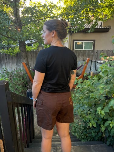 Customer's rear view of brown Utility Shorts, showcasing the fit and pocket placement outdoors.