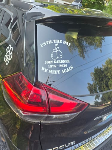 Customer's white custom boxing gloves memorial decal applied to the rear window of a black car.