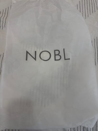 Customer's white Weekender Dust Cover with the NOBL logo centered on the fabric.