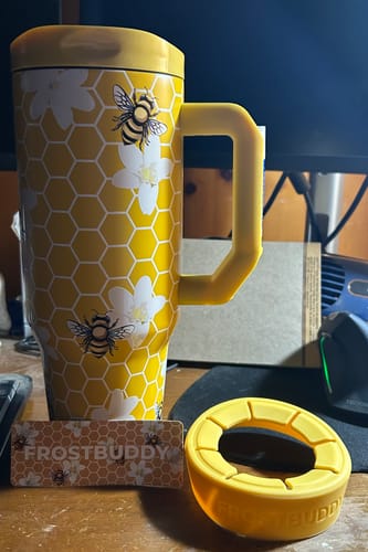 Customer's yellow Thicc Buddy mug with bee and honeycomb pattern, including lid, rubber base, and branding card.