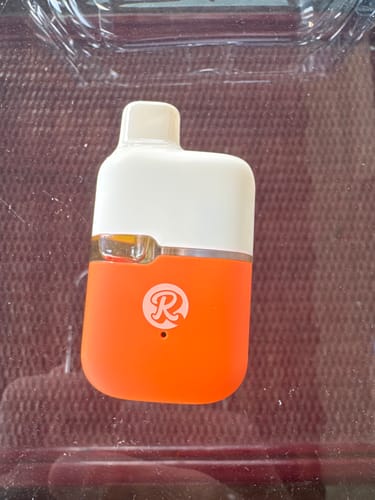 Customer's compact THC-A vape with a white top and orange bottom, featuring a logo, shown in a plastic case.